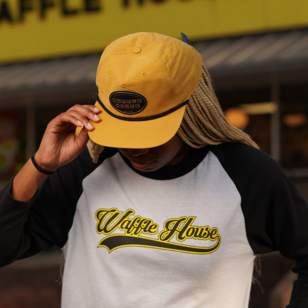 top view of woman wearing retro yellow Waffle House patch hat