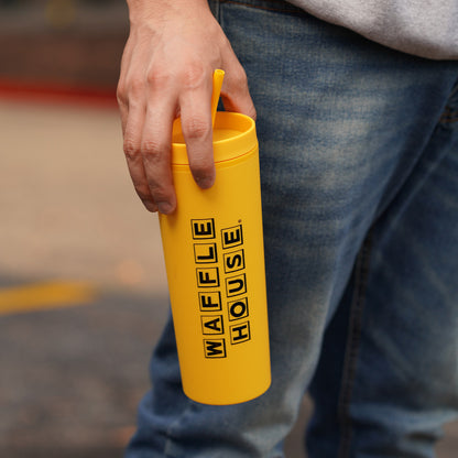 hand holding a yellow tumbler with straw and black Waffle House logo 