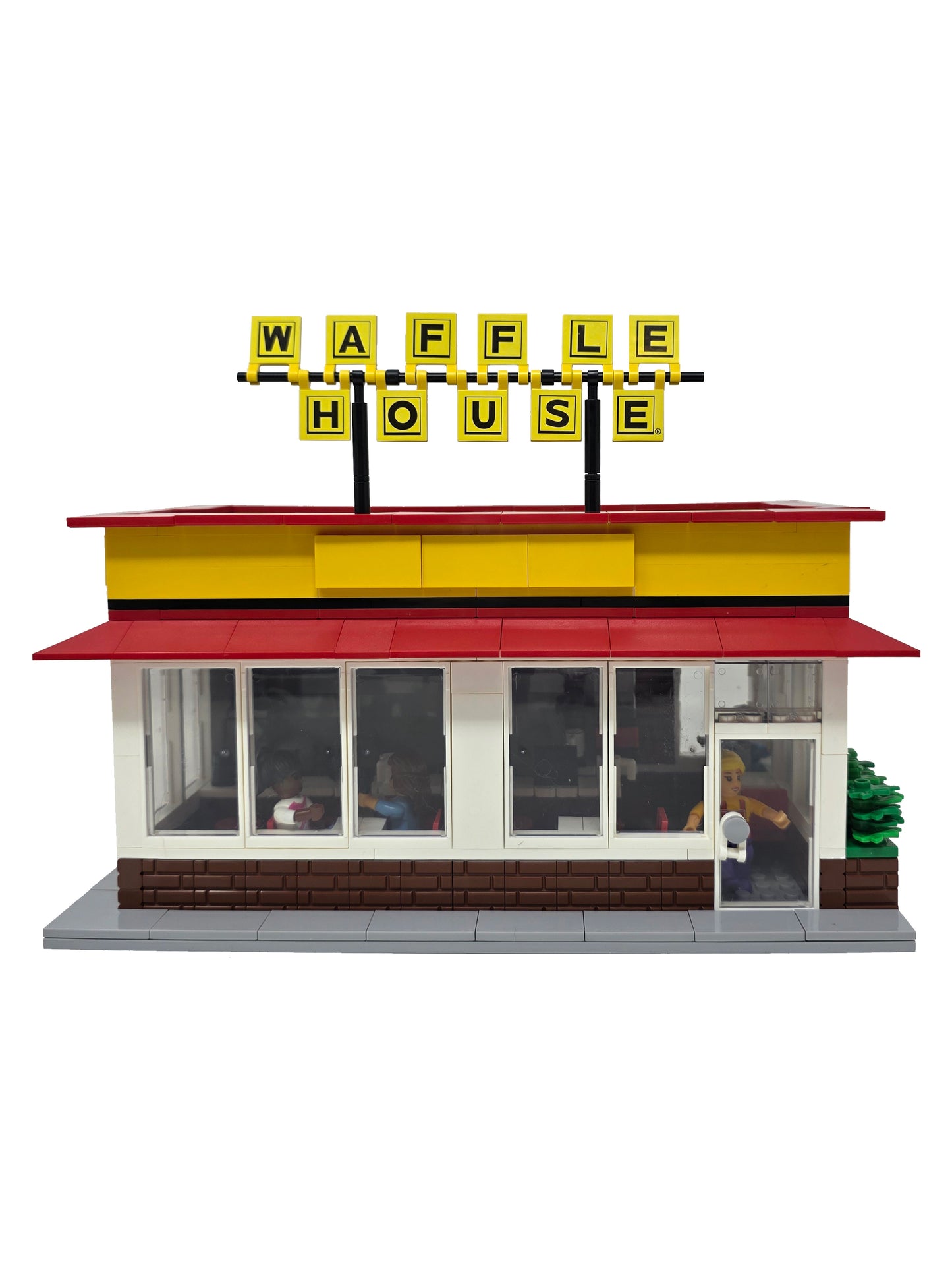 Model of a Waffle House restaurant with a red roof and yellow facade.