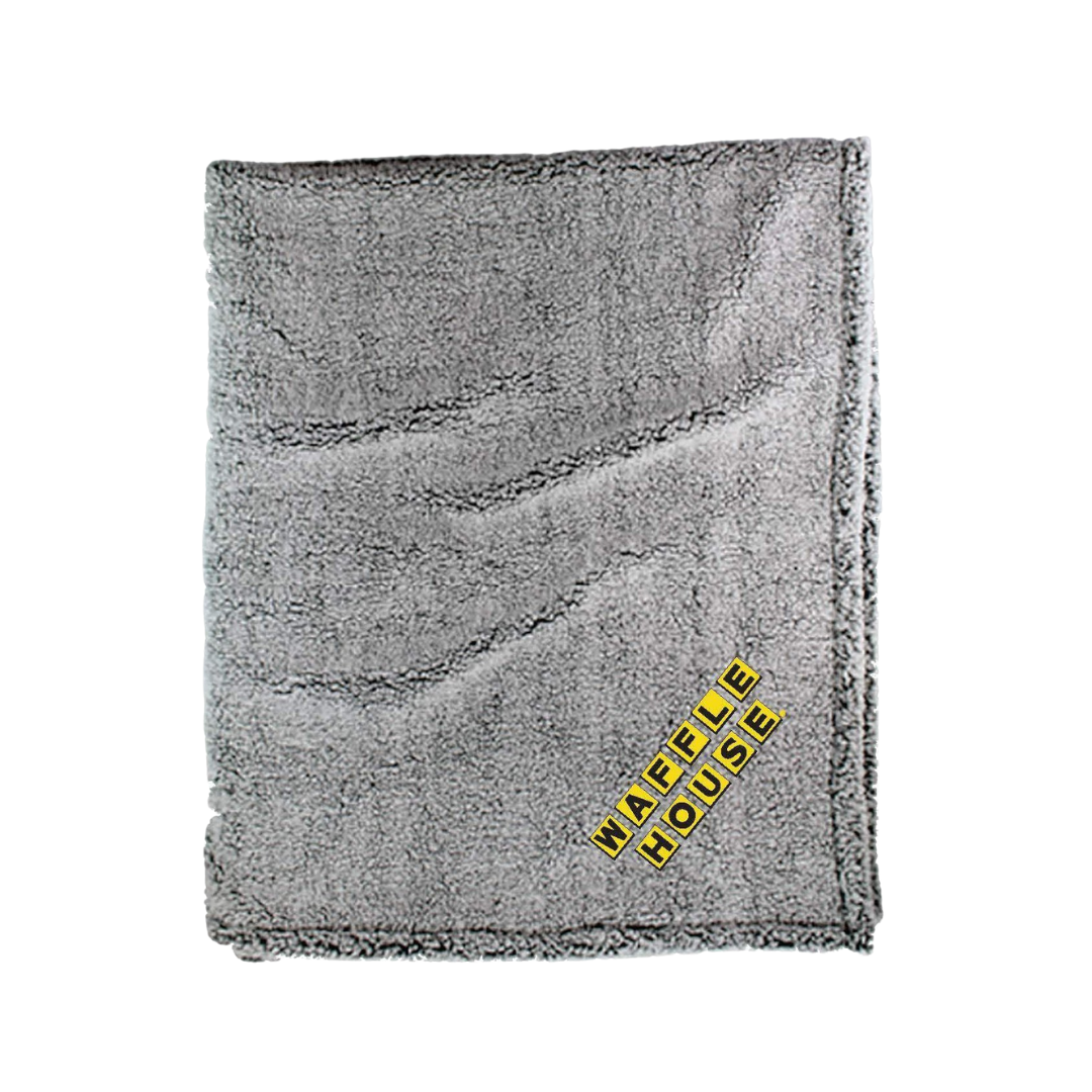 Grey Sherpa folded blanket with yellow and black Waffle House logo in corner.