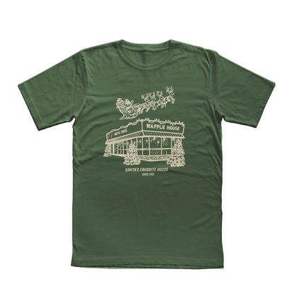 Green t-shirt featuring a cream-colored drawing of Santa and his reindeer flying over a snowy Waffle House with the words “Santa’s Favorite House Since 1955.