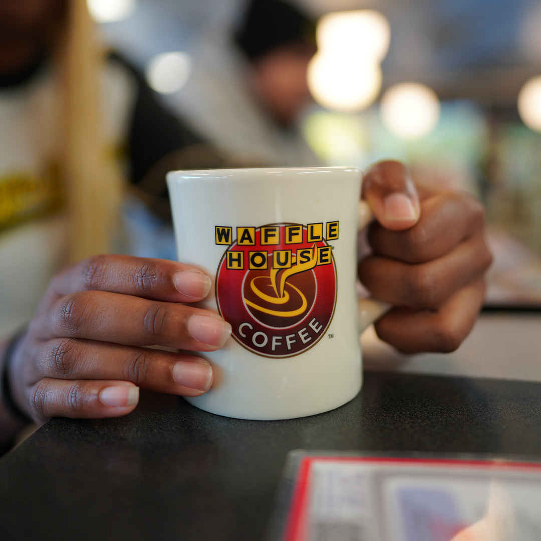 Waffle House coffee mug being held by persons hands