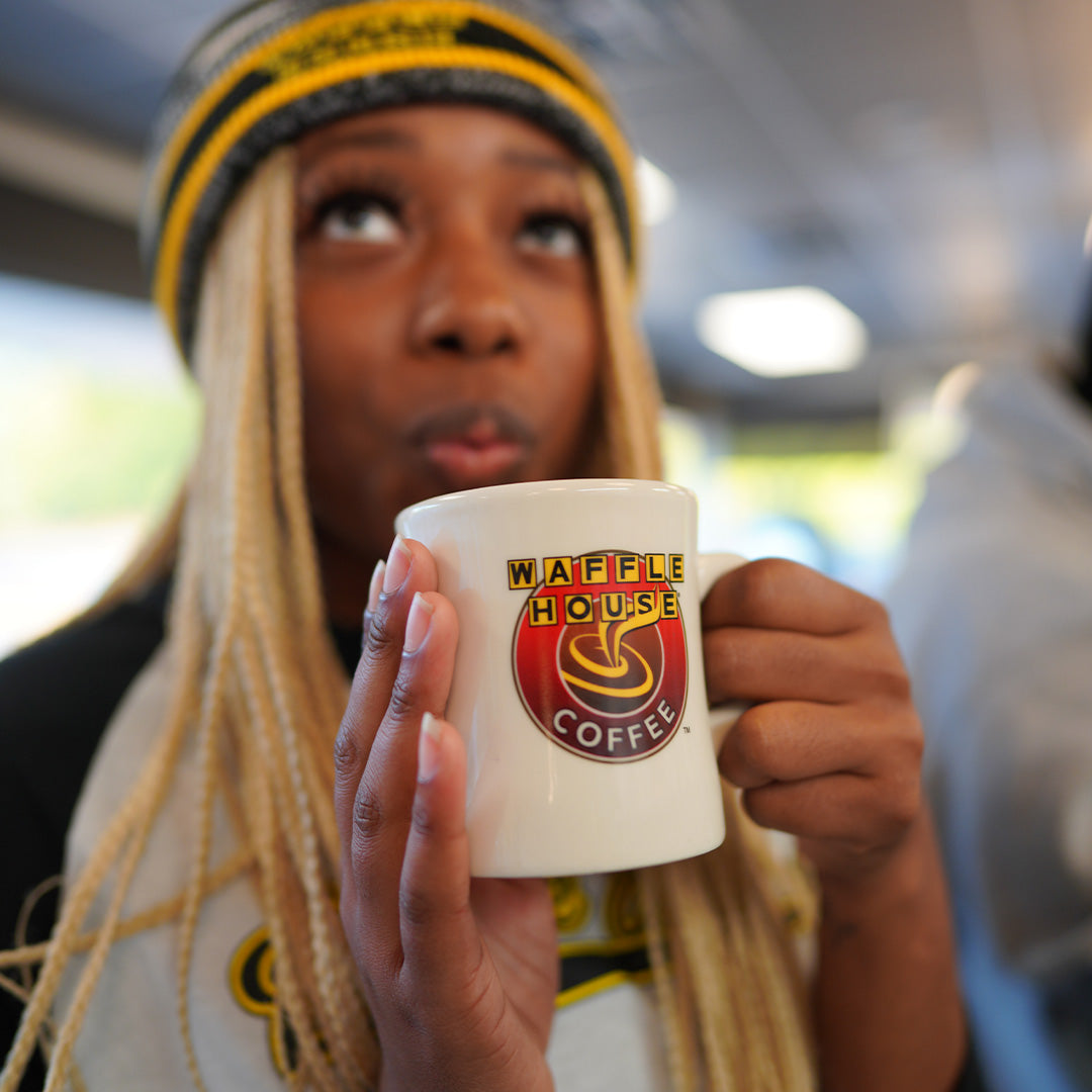 woman holding Waffle House coffee mug 