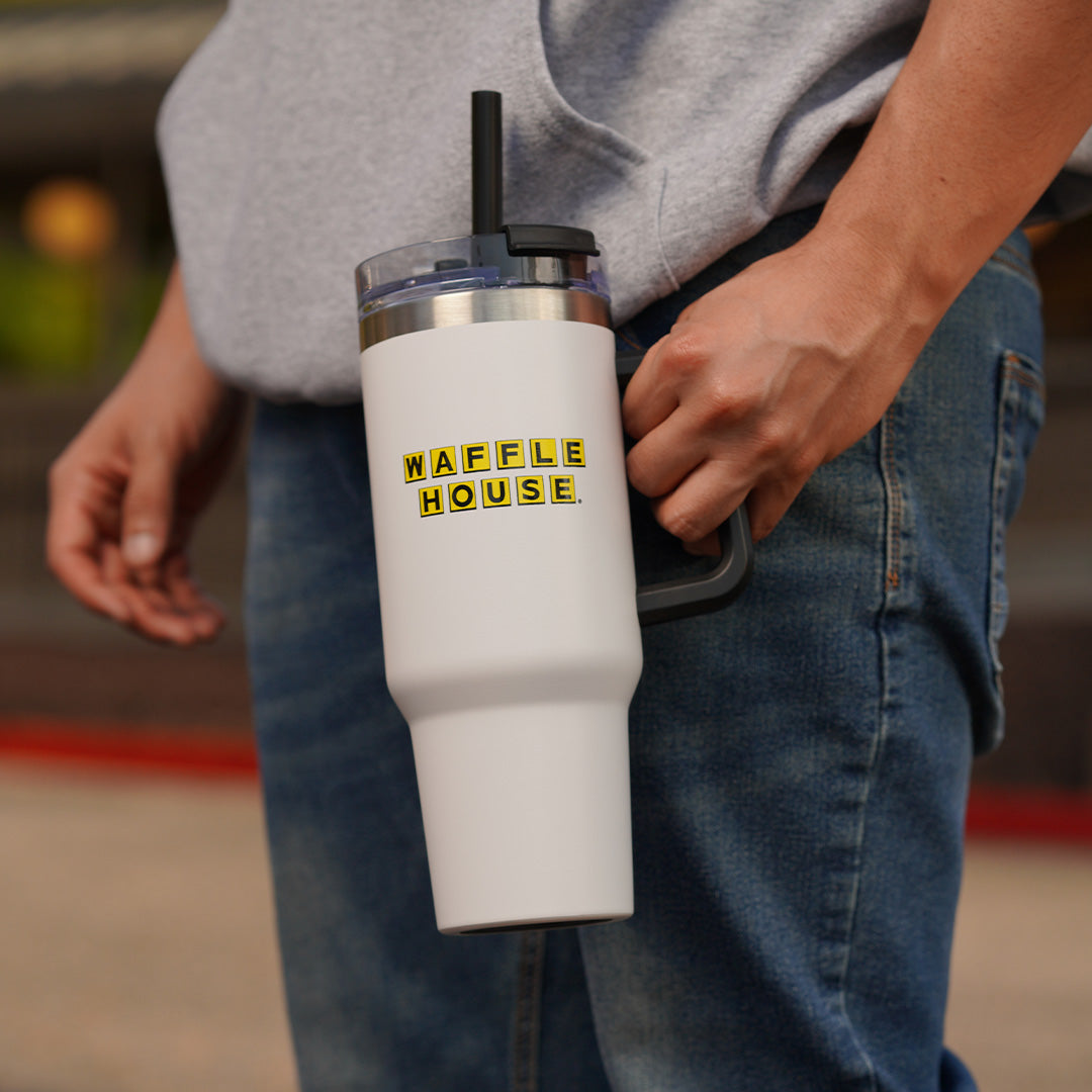 white tumbler with straw with Waffle House logo being held by persons hand