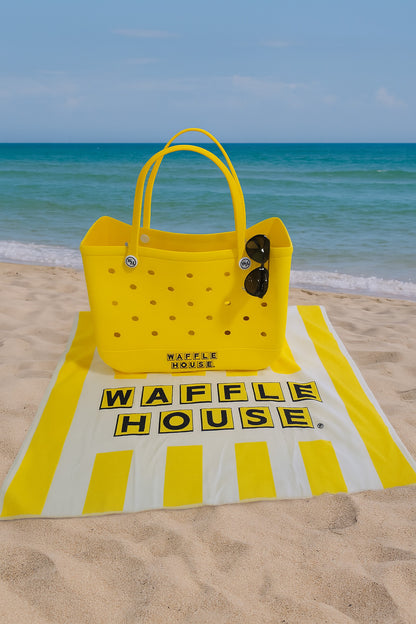 Yellow tote bag on a Waffle House branded towel at the beach