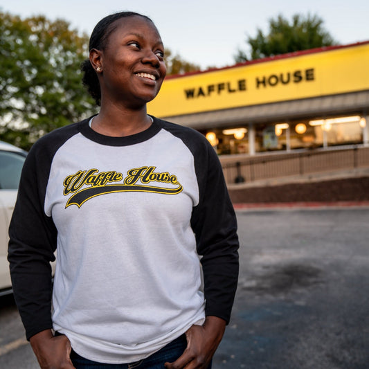 woman wearing black and white Waffle House t-shirt standing in front of Waffle House store