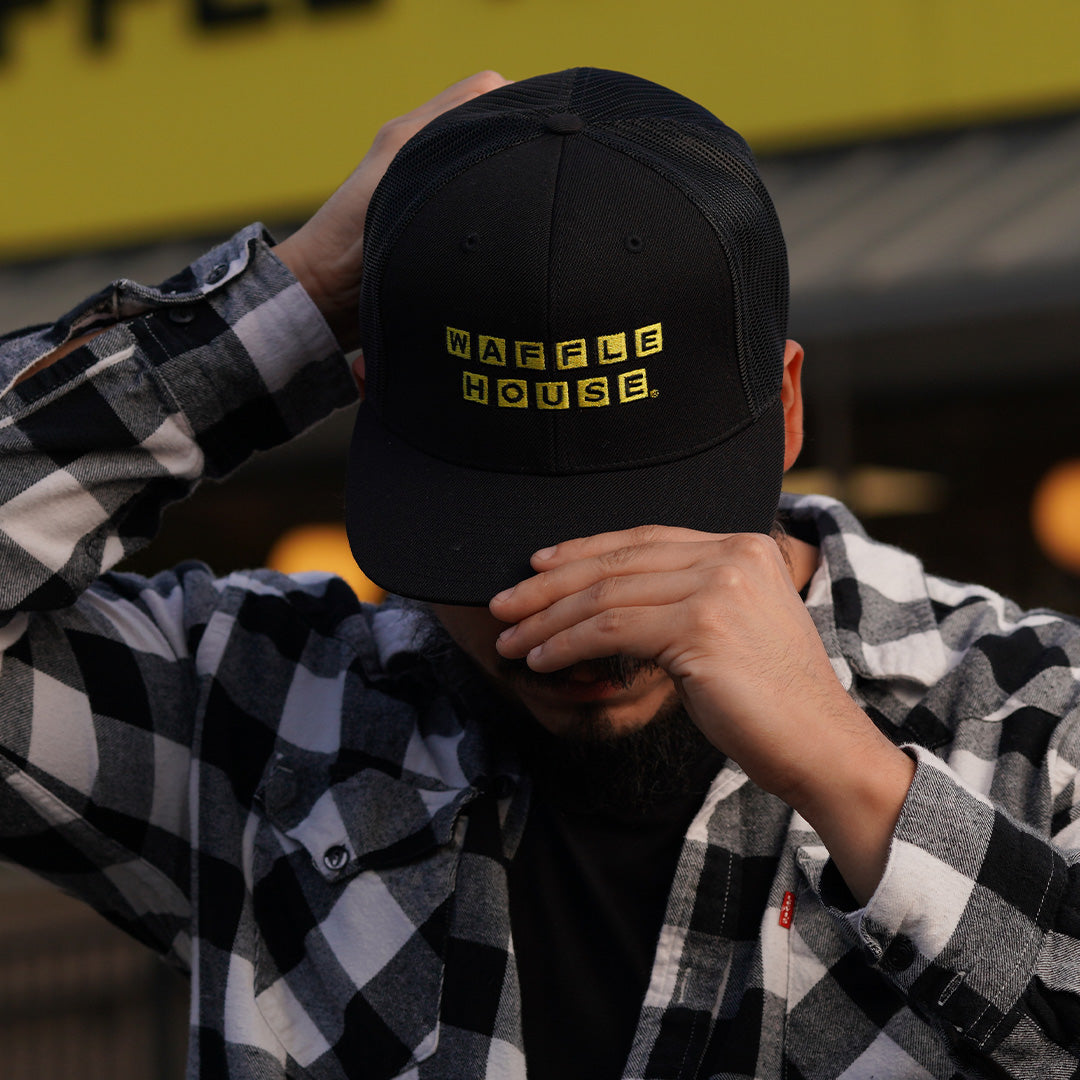 man wearing black trucker hat with yellow Waffle House logo