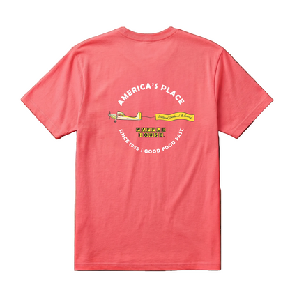Back of coral Waffle House t-shirt with arched "America's Place" text above a yellow banner plane pulling a "Scattered, Smothered & Covered" flag, Waffle House logo below, "Since 1955 – Good Food Fast" along bottom arc