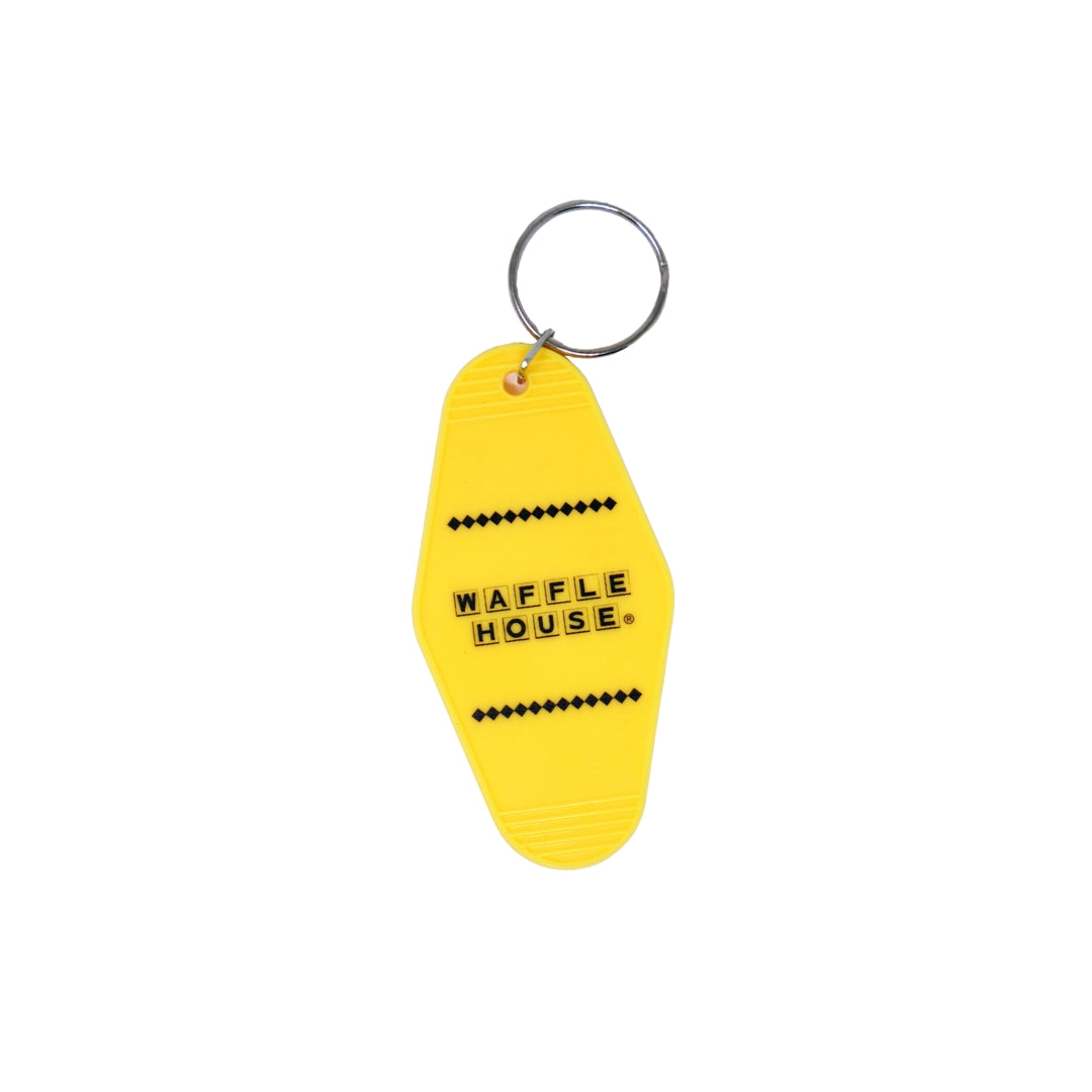 Yellow motel keychain with black Waffle House logo laying flat on white background